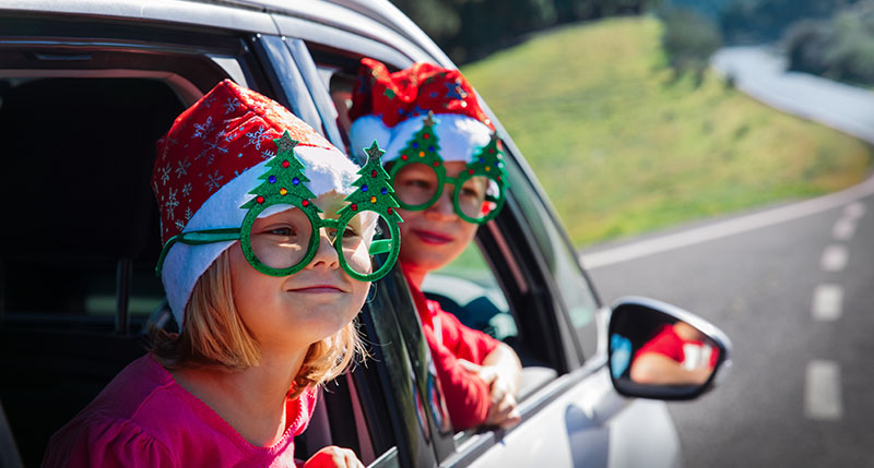 Dos niños viajan en coche por Navidad