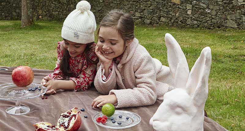 Dos niñas de picnic con looks de entretiempo de Nanos